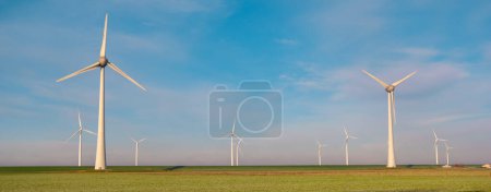 Photo for Windmill park with wind mill turbines during winter generating electricity with a blue sky green energy concept - Royalty Free Image