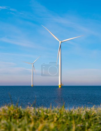 Foto de Vista en el parque de molinos de viento con turbinas de molinos de viento durante el invierno generando electricidad con un concepto de energía verde cielo azul - Imagen libre de derechos