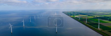 Foto de Vista aérea en el parque de molinos de viento con turbinas de molinos de viento durante el invierno enormes turbinas de molinos de viento en el lago Ijsselmeer en los Países Bajos - Imagen libre de derechos