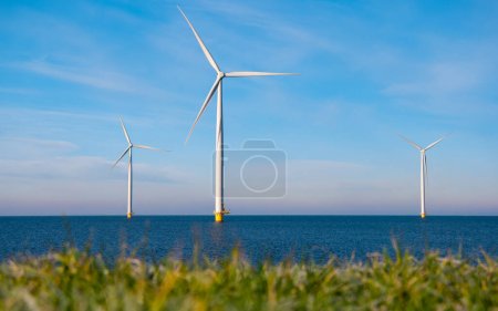 Luftaufnahme im Windmühlenpark mit Windkraftanlagen, die im Winter mit blauem Himmel grünen Strom erzeugen