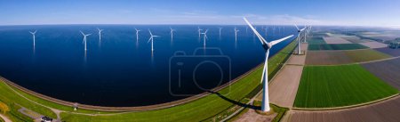 Foto de Vista aérea en el parque de molinos de viento con turbinas de molinos de viento durante el invierno generando electricidad con un concepto de energía verde cielo azul. Molino de viento con nubes - Imagen libre de derechos