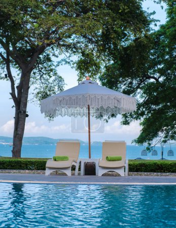 Foto de Sillas de playa en una piscina con sombrillas, silla de dek en una piscina - Imagen libre de derechos