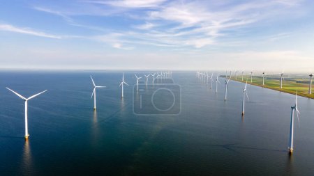 Foto de Drone Vista aérea en el parque de molinos de viento con turbinas de molinos de viento en el océano y un cielo azul en los Países Bajos - Imagen libre de derechos