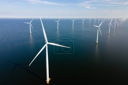 Foto de Drone Vista aérea en el parque de molinos de viento con turbinas de molinos de viento en el océano y un cielo azul en los Países Bajos - Imagen libre de derechos