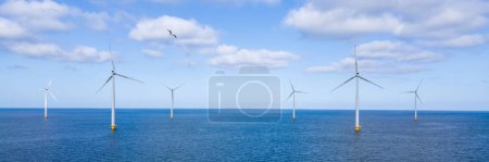 Foto de Panorama de un parque de molinos de viento con turbinas de viento en el océano - Imagen libre de derechos