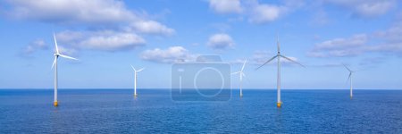 Foto de Drone Vista aérea en el parque de molinos de viento con turbinas de molinos de viento en el océano al atardecer - Imagen libre de derechos