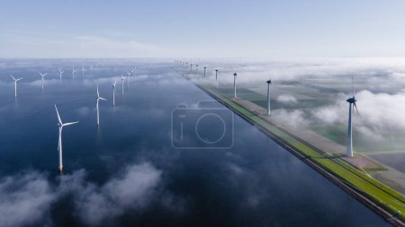 Foto de Drone Vista aérea en el parque de molinos de viento con turbinas de molinos de viento en el océano azul. - Imagen libre de derechos