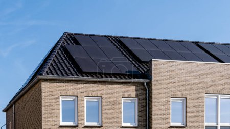 Téléchargez les photos : Maisons nouvellement construites avec des panneaux solaires noirs fixés au toit - en image libre de droit