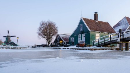 Téléchargez les photos : Lever de soleil au village du moulin à vent de Zaanse Schans en hiver avec paysage enneigé aux Pays-Bas Village hollandais en hiver - en image libre de droit