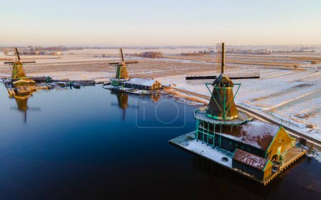 Photo for Snow at the Zaanse Schans windmill village during winter with snow landscape in the Netherlands Holland village in winter - Royalty Free Image