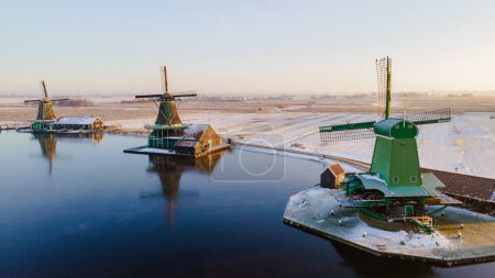 Foto de Zaanse Schans pueblo molino de viento durante el invierno con paisaje de nieve en los Países Bajos pueblo de Holanda en invierno. Molinos históricos de madera - Imagen libre de derechos