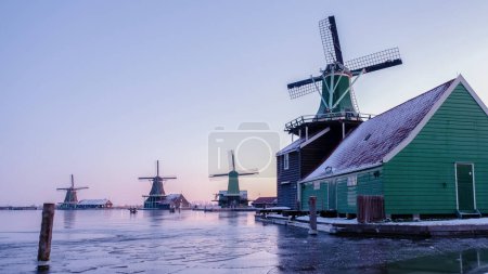 Téléchargez les photos : Village du moulin à vent de Zaanse Schans en hiver avec paysage enneigé aux Pays-Bas Village hollandais en hiver au lever du soleil - en image libre de droit