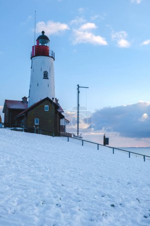 Téléchargez les photos : Phare d'Urk avec paysage enneigé en hiver aux Pays-Bas. - en image libre de droit