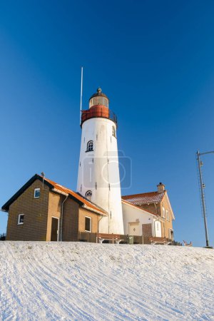 Photo for Lighthouse of Urk during winter with snow landscape in the Netherlands - Royalty Free Image