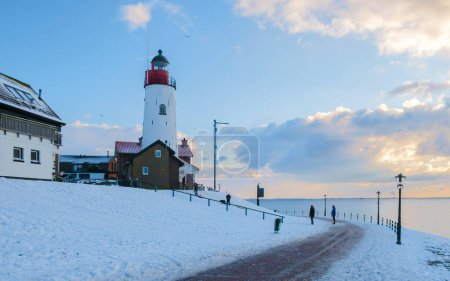 Téléchargez les photos : Phare d'Urk en hiver avec paysage enneigé aux Pays-Bas par une journée ensoleillée - en image libre de droit