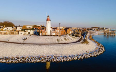 Téléchargez les photos : Vue panoramique sur le phare d'Urk en hiver avec paysage enneigé aux Pays-Bas - en image libre de droit