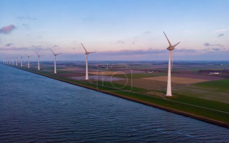 Foto de Puesta de sol en el parque de molinos de viento con turbinas de viento en los Países Bajos - Imagen libre de derechos