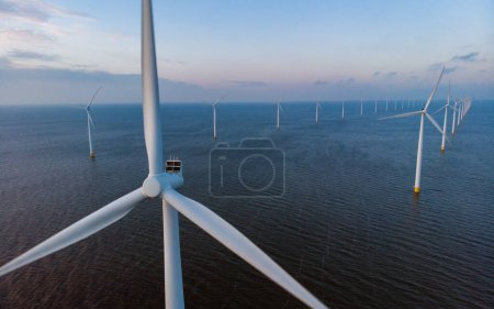 Téléchargez les photos : Éoliennes aux Pays-Bas pendant le coucher du soleil dans le Flevoland - en image libre de droit
