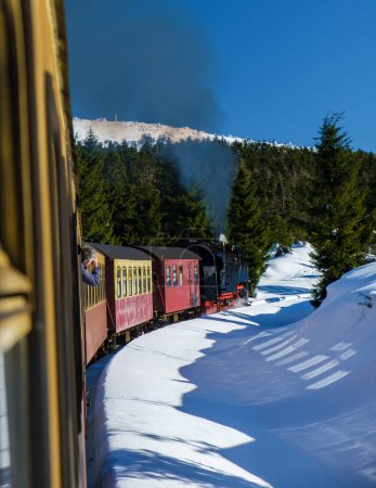 Téléchargez les photos : Train à vapeur pendant l'hiver dans la neige dans le parc national du Harz Allemagne, Locomotive à vapeur rétro Brocken Bahn sur le chemin à travers le paysage hivernal, Brocken, Harz Allemagne - en image libre de droit