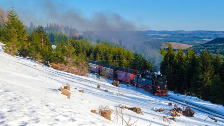 Foto de Tren de vapor durante el invierno en la nieve en el parque nacional de Harz Alemania en un día soleado - Imagen libre de derechos