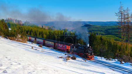 Foto de Antiguo tren de vapor retro vintage durante el invierno en la nieve en el parque nacional de Harz Alemania, tren de vapor Brocken Bahn en el camino a través del paisaje de invierno, Brocken, Harz Alemania - Imagen libre de derechos