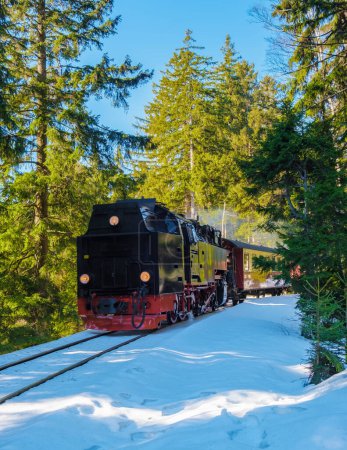 Téléchargez les photos : Vieux train à vapeur rétro vintage pendant l'hiver dans la neige dans le parc national du Harz Allemagne, train à vapeur Brocken Bahn sur le chemin à travers le paysage hivernal, Brocken, Harz Allemagne - en image libre de droit