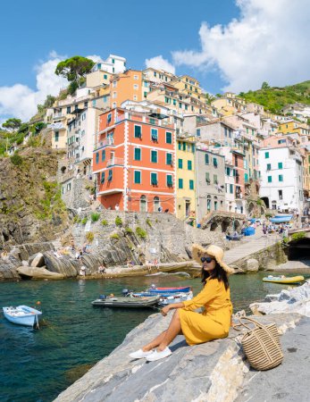 Foto de Las mujeres asiáticas visitan Riomaggiore Cinque Terre maravillosa vista de Liguria, Italia. el paisaje marino del mar Mediterráneo. Concepto de viaje fondo. - Imagen libre de derechos