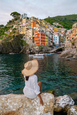 Téléchargez les photos : Les femmes asiatiques visitent Riomaggiore Cinque Terre vue magnifique sur la Ligurie, Italie. paysage marin de la mer Méditerranée. Concept de voyage arrière-plan. - en image libre de droit