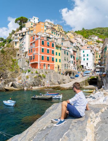 Foto de Hombres caucásicos visitando Riomaggiore Cinque Terre. Magnífica vista de Liguria, Italia y Europa. el paisaje marino del mar Mediterráneo. Concepto de viaje fondo. - Imagen libre de derechos