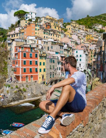 Foto de Jóvenes caucásicos visitando Riomaggiore Cinque Terre. Magnífica vista de Liguria, Italia y Europa. el paisaje marino del mar Mediterráneo. Concepto de viaje fondo. - Imagen libre de derechos