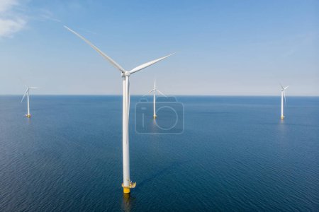 Photo for Windmill turbines at sea generate green energy in the Netherlands. Drone view at windmill park in the ocean - Royalty Free Image