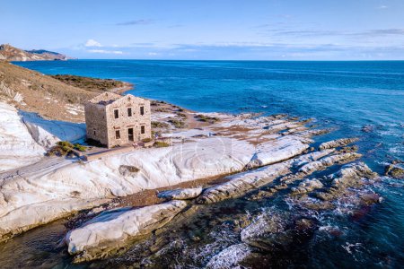 Foto de Punta Bianca, Agrigento en Sicilia Italia Playa blanca con ruinas antiguas de una casa de piedra abandonada en acantilados blancos. Sicilia Italia - Imagen libre de derechos