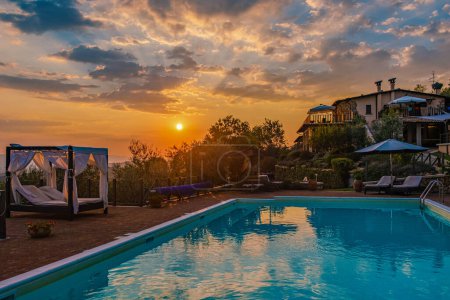 Luxury country house with swimming pool in Italy. Pool and old farm house during sunset in central Italy