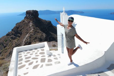 Foto de Santorini Grecia, una mujer asiática feliz en vacaciones de lujo Oia Santorini Island Grecia visita el pueblo blanco con hermoso edificio con vistas al océano caldera - Imagen libre de derechos