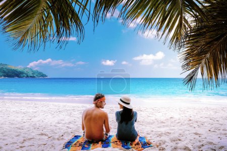 Foto de Playa blanca tropical en la isla de Praslin Seychelles, feliz Pareja joven hombre y mujer durante las vacaciones Vacaciones en la playa relajándose bajo una palmera - Imagen libre de derechos