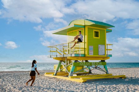 Téléchargez les photos : Miami South Beach Floride États-Unis, couple par refuge de sauveteurs pendant Sunrise Miami Beach, hommes heureux, et la femme sur la plage - en image libre de droit