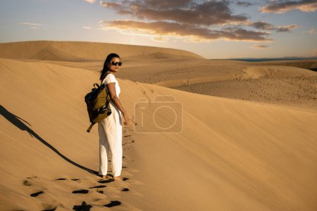 Photo for Woman walking at the sand dunes of Maspalomas Gran Canaria Spain, girl at the sand dunes desert of Maspalomas Spain Europe - Royalty Free Image
