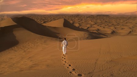 Foto de Dubai desert sand dunes, men watching the sunset in the Dubai desert safari, United Arab Emirates vacation, men on vacation in Dubai Emirates - Imagen libre de derechos