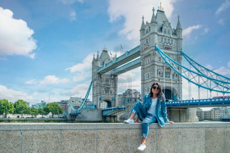 Photo for Asian women on a city trip in London by the river Thames at the famous places in London, Tower Bridge during summer - Royalty Free Image