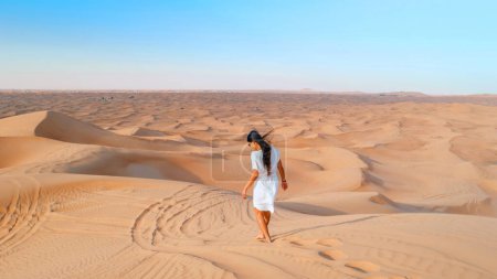 Photo for Dubai dessert sand dunes, Asian women on Dubai desert safari,United Arab Emirates, woman vacation in Dubai visit the sand dunes - Royalty Free Image
