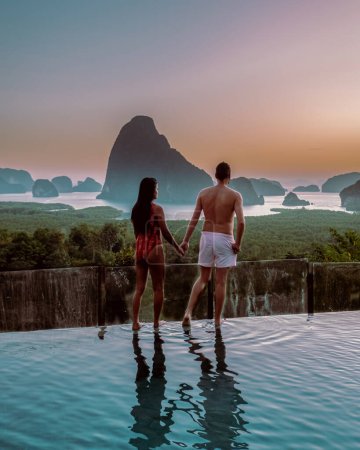 Photo for Phangnga Bay Thailand, couple on the edge of an swimming pool watching sunrise Thailand infinity pool honeymoon - Royalty Free Image