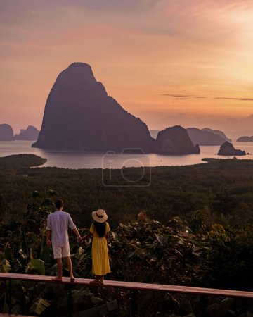 Foto de Phangnga Bay Tailandia, pareja de vacaciones observando el amanecer sobre la bahía de Phangnga Mirador de Samethnagshe luna de miel - Imagen libre de derechos