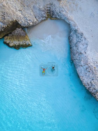 Foto de Tres Trapi Steps Triple Steps Beach, Aruba completamente vacío, una playa popular entre los lugareños y turistas, y el océano cristalino Aruba. Caribe, hombres y mujeres nadando en el océano azul - Imagen libre de derechos