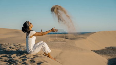 Photo for Woman walking at the beach of Maspalomas Gran Canaria Spain, a girl at the sand dunes desert of Maspalomas Spain Europe - Royalty Free Image