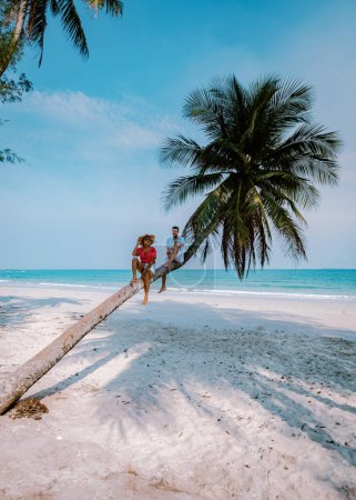 Photo for Couple climbing in a palm tree in Thailand, Wua Laen beach Chumphon area Thailand, palm tree hanging over the beach with a couple on vacation in Thailand Asia - Royalty Free Image