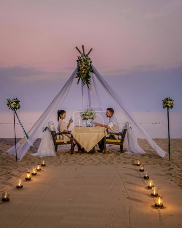 Foto de Cena romántica en la playa, cena de luna de miel en la playa al atardecer Tailandia, puesta de San Valentín Asia - Imagen libre de derechos