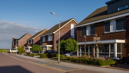 Foto de Zona suburbana holandesa con casas familiares modernas, casas familiares modernas de nueva construcción en los Países Bajos, casa familiar holandesa durante el verano - Imagen libre de derechos
