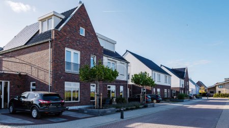 Téléchargez les photos : Zone néerlandaise de banlieue avec des maisons familiales modernes, maisons familiales modernes nouvellement construites aux Pays-Bas, maison familiale néerlandaise avec un ciel bleu - en image libre de droit