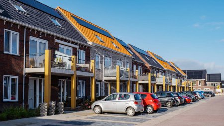 Photo for New houses with solar panels attached on the roof against a sunny sky, new buildings with black solar panels. Zonnepanelen, Zonne energie, Translation: Solar panel Sun Energy. Netherlands - Royalty Free Image