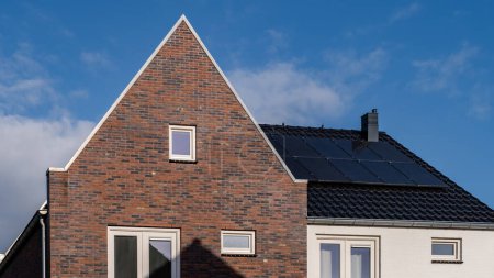 Téléchargez les photos : Maisons nouvellement construites avec des panneaux solaires fixés sur le toit contre un ciel ensoleillé, marché du logement aux Pays-Bas - en image libre de droit